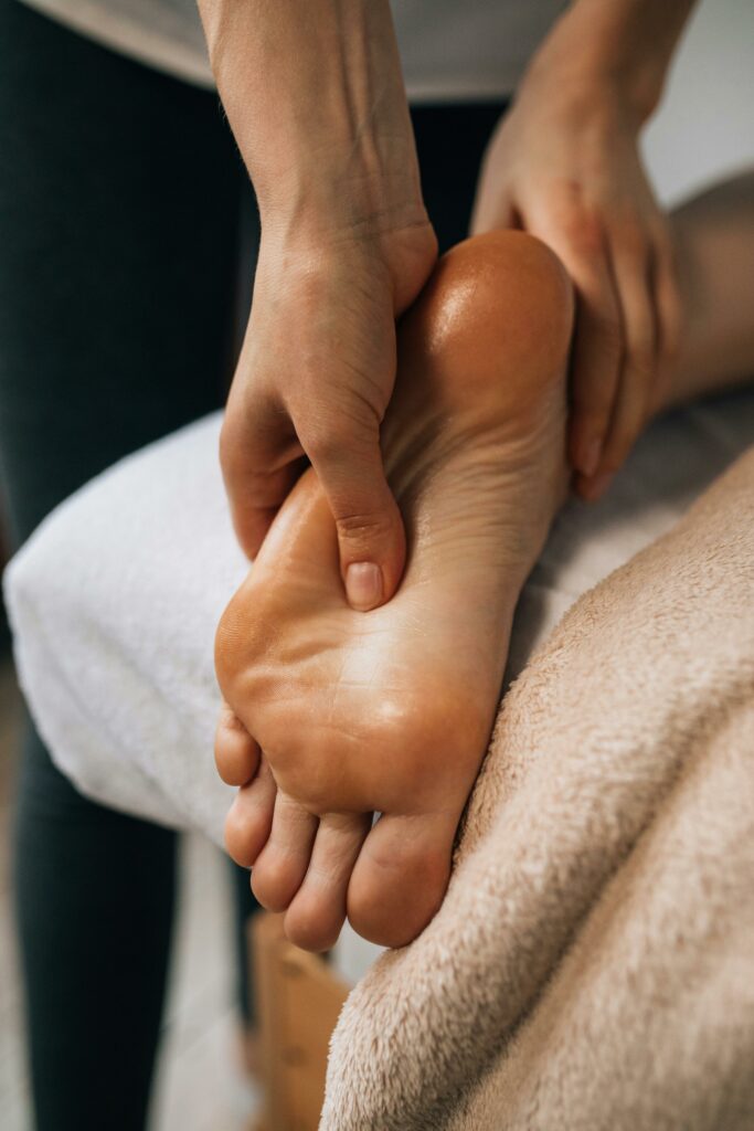 pexels-photo-6628700-6628700 Hands massaging a foot to provide relaxation and promote wellness indoors.