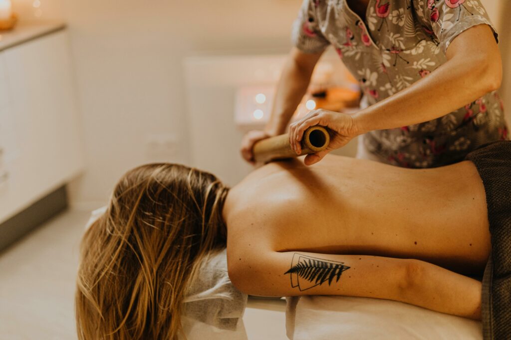 pexels-photo-6629529-6629529 A serene spa experience with a massage therapist working on a woman's back using bamboo sticks.
